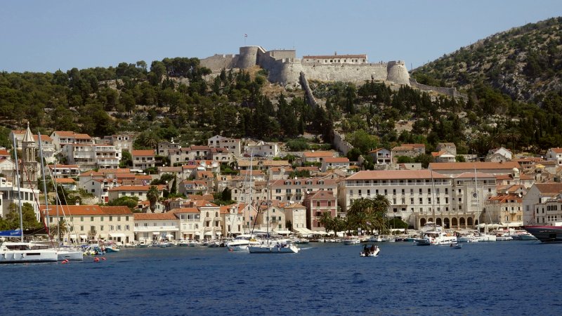 La città di Hvar si estende attorno al porto sottostante, mentre le isole al largo di Hvar e l'isola di Vis sono visibili più lontano.